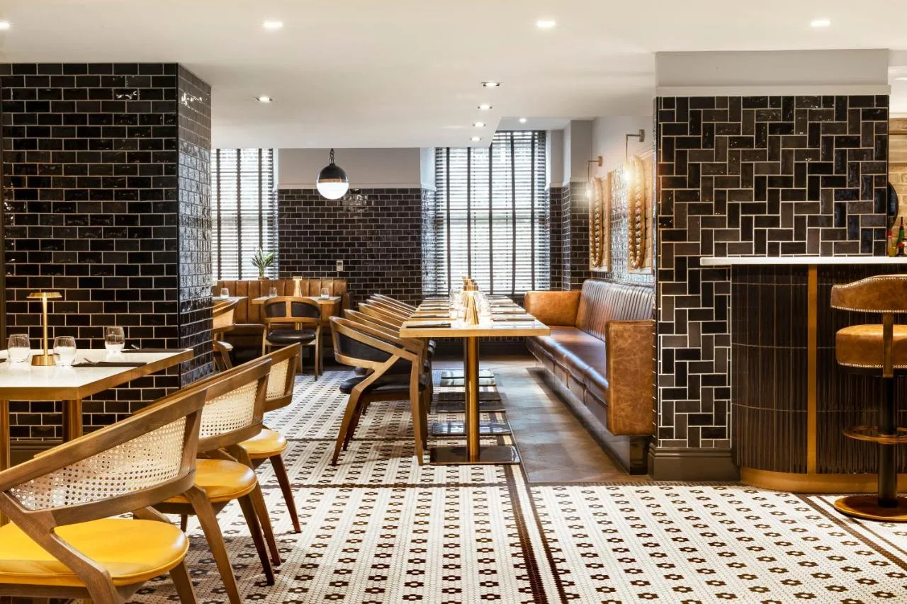 a restaurant with tables and chairs in a room at Courtyard by Marriott Edinburgh in Edinburgh