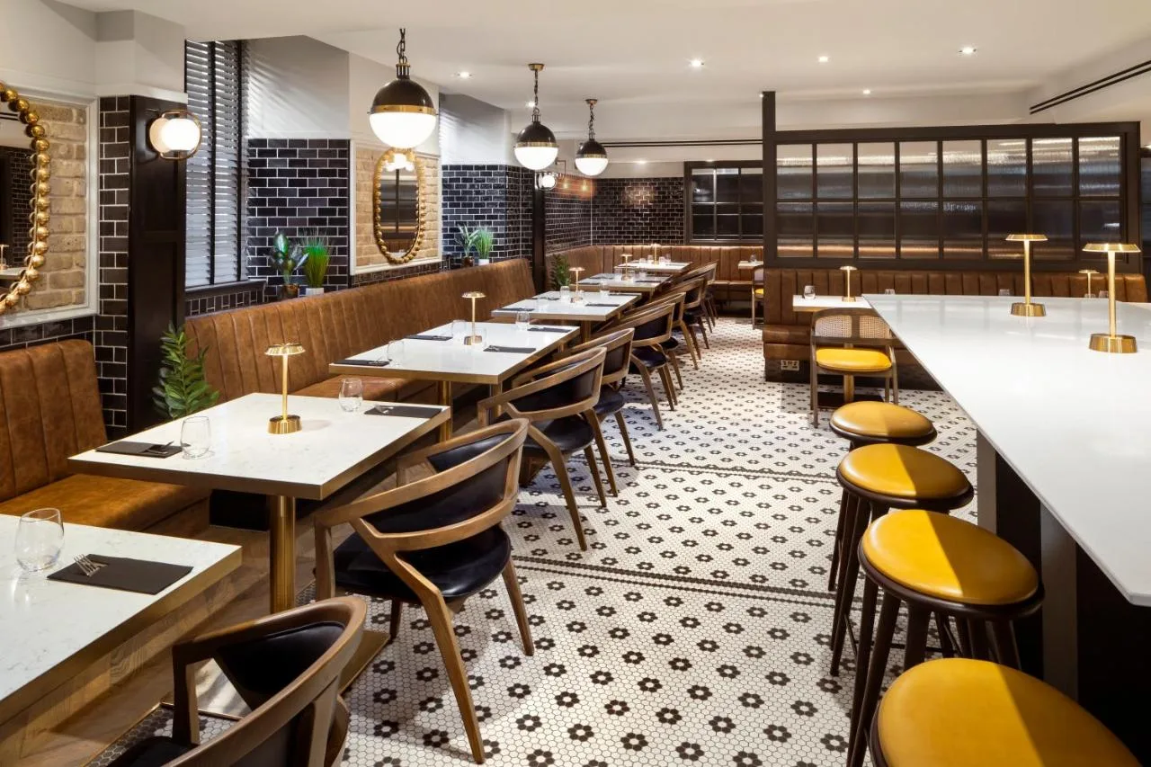 a row of tables in a restaurant with yellow chairs at Courtyard by Marriott Edinburgh in Edinburgh