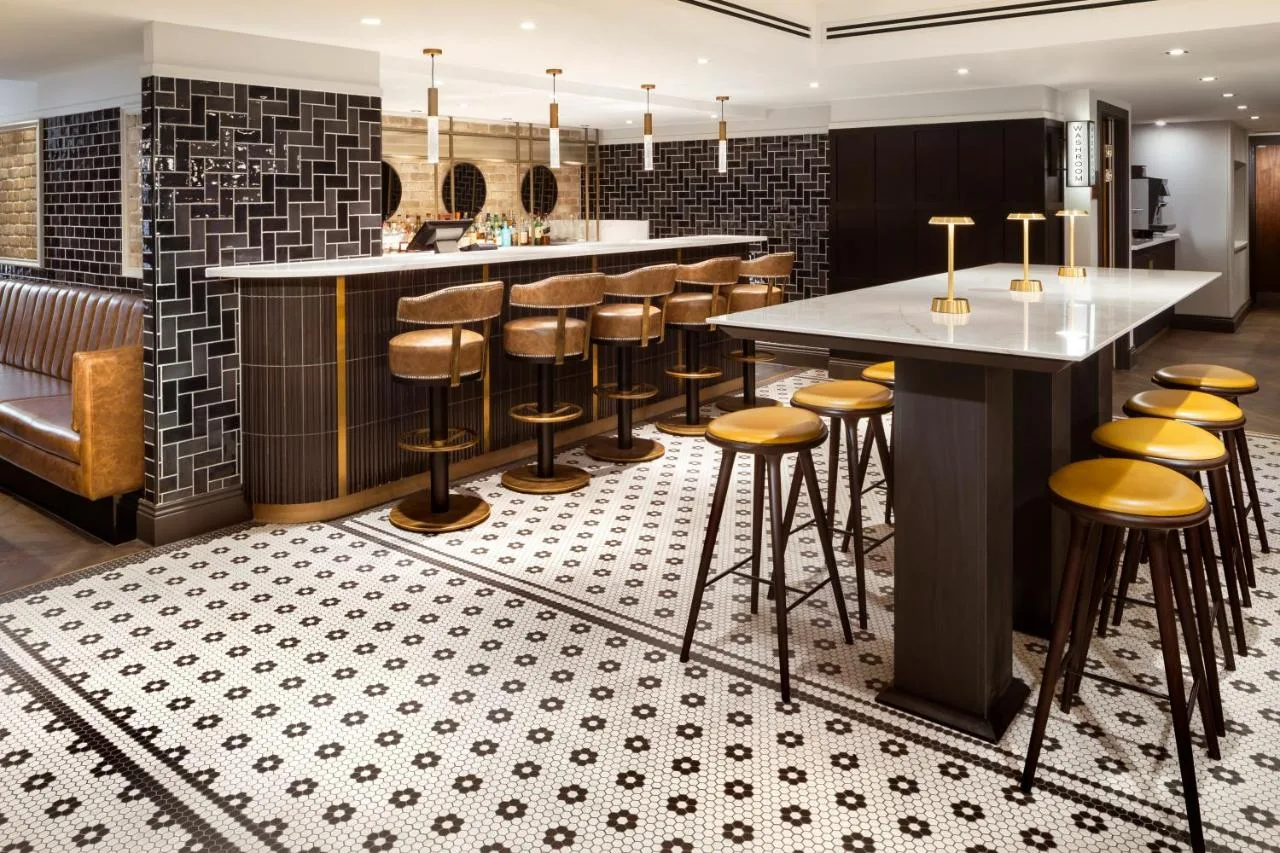 a kitchen with a bar and stools on a floor at Courtyard by Marriott Edinburgh in Edinburgh